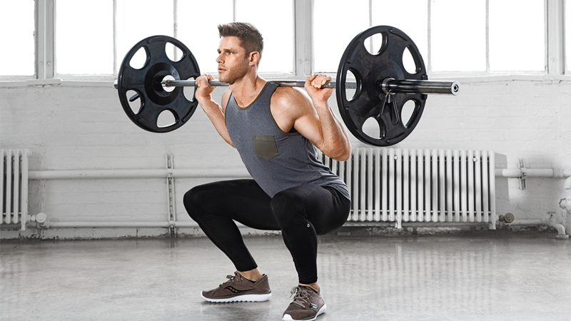 Bài tập gánh tạ đòn (Squat) bắt buộc toàn bộ vùng cơ lõi và cơ bụng phải gồng chặt để giữ thăng bằng.